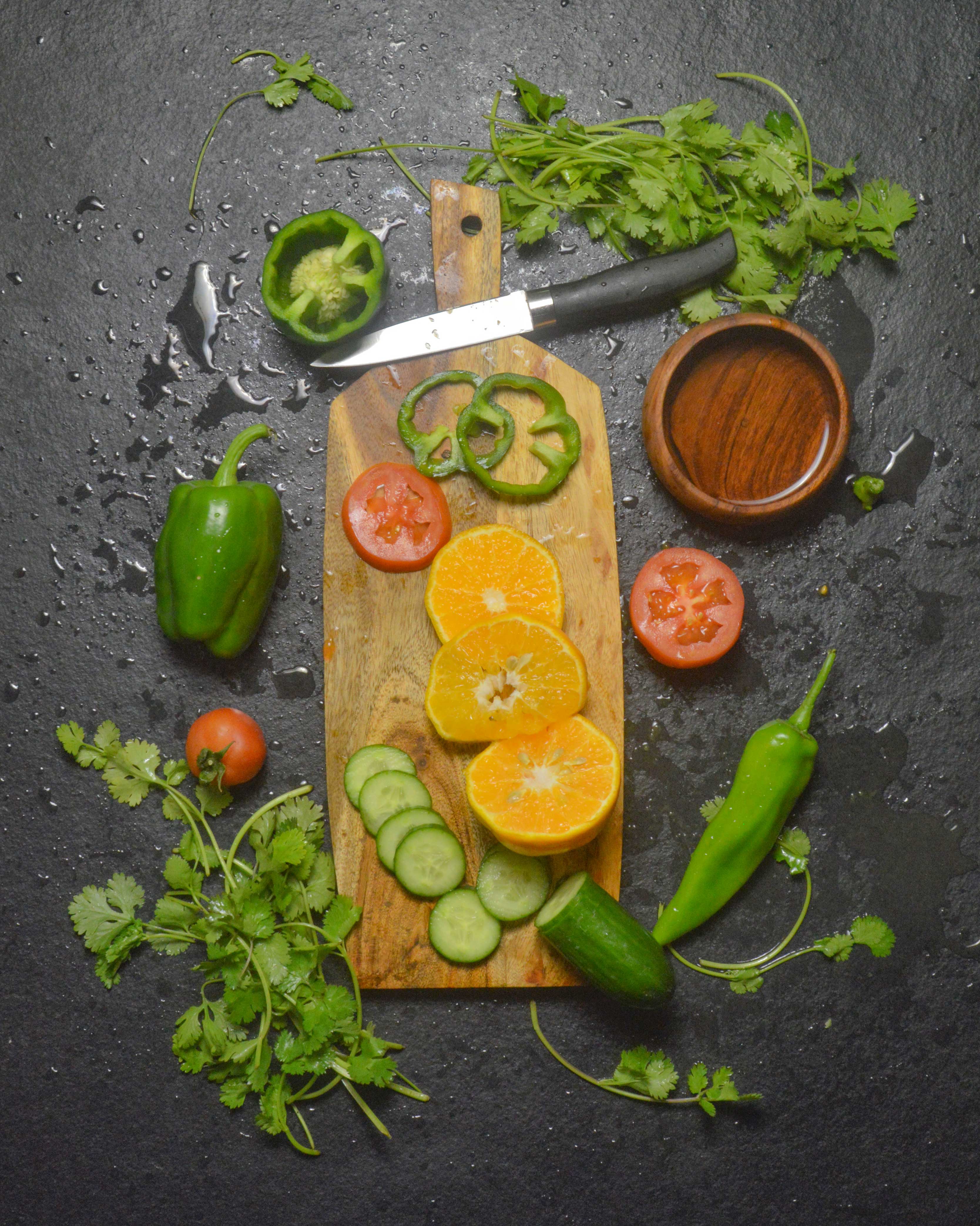 Acacia wood cutting board with sliced colorful vegetables - organic meal prep on artisan kitchen board