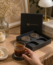 Dark brown round coaster design shown with its black presentation packaging.