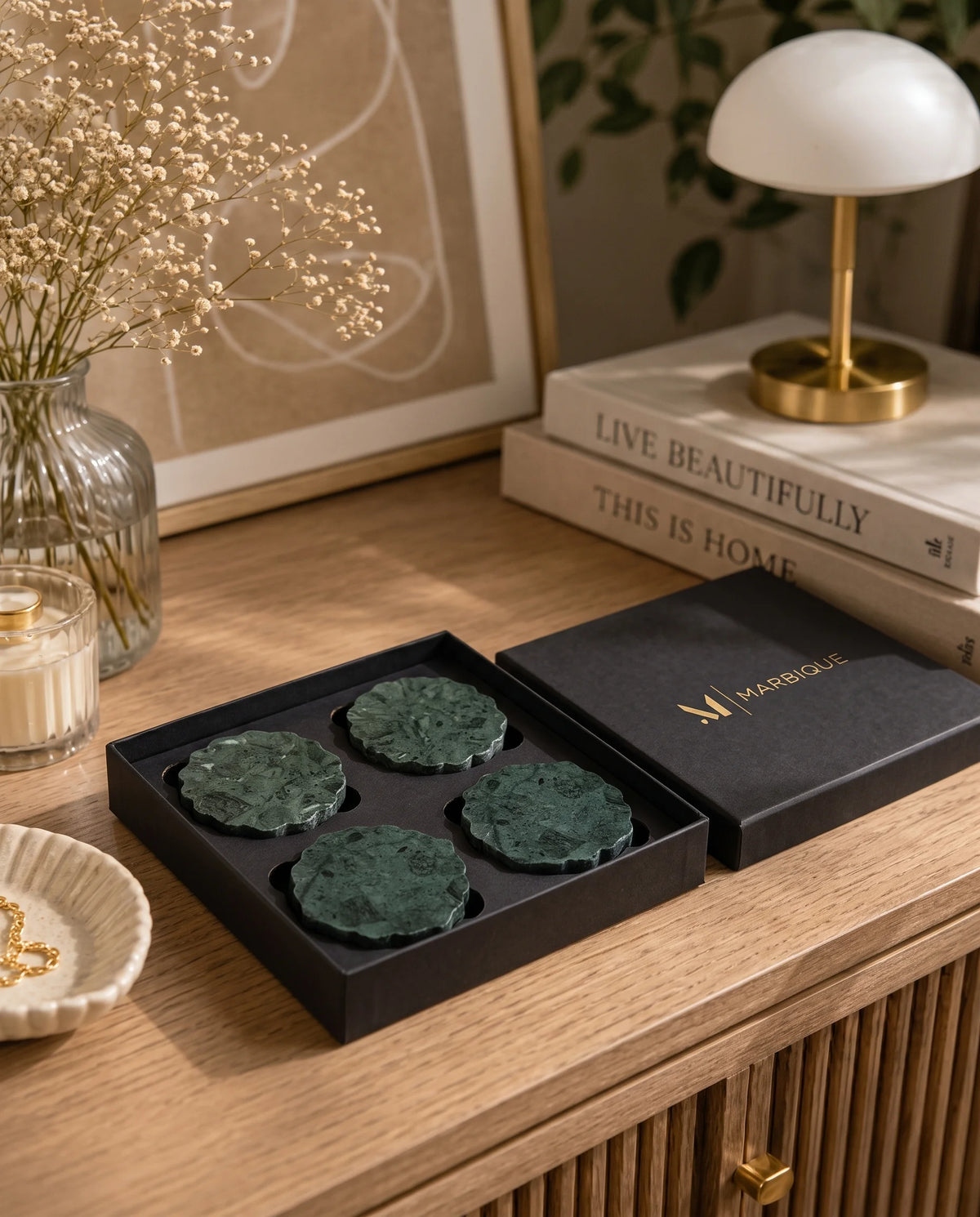 Dark green flower-edged circular coaster designs displayed with black presentation packaging.