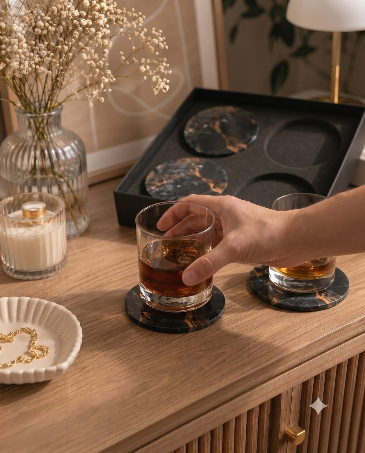 Black round coaster designs with contrasting veins photographed beside presentation packaging.