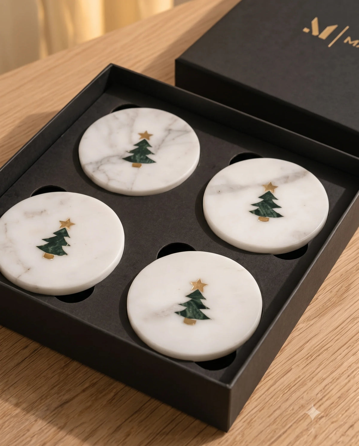 Close view of a green tree and small gold-tone star motif on a white round coaster.