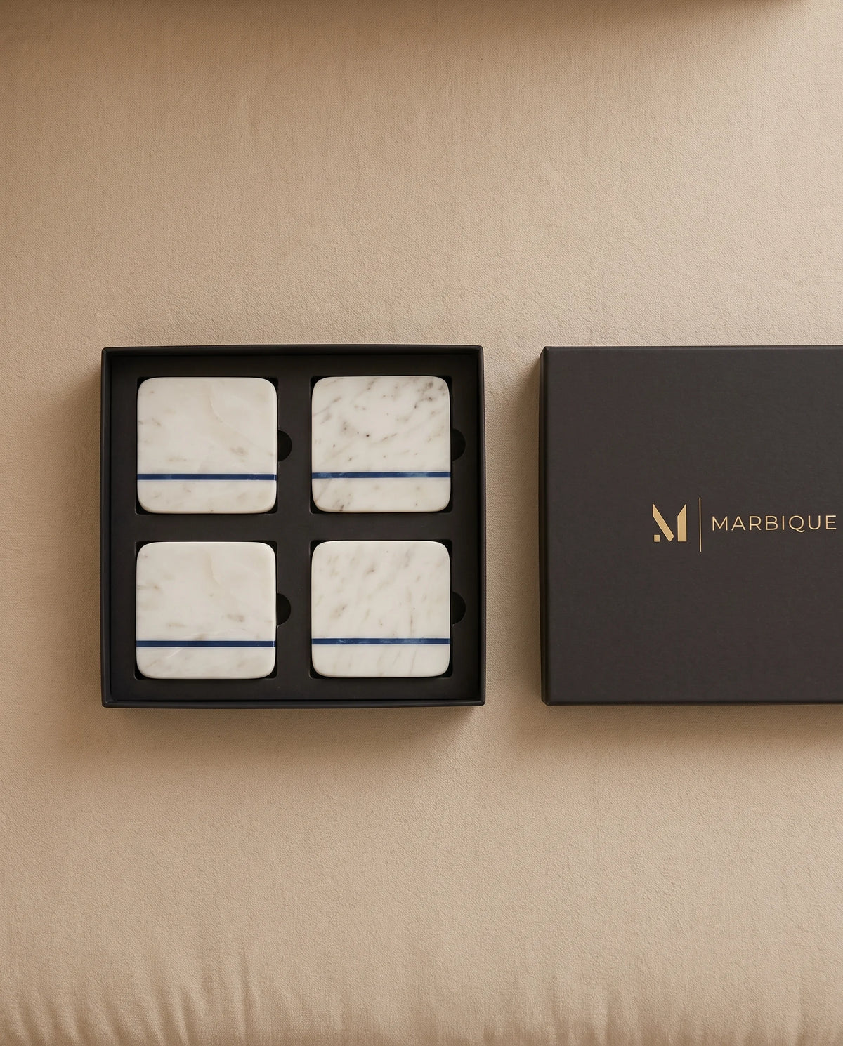 White square coaster designs with a narrow blue line arranged on a table.