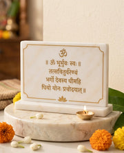 White Gayatri Mantra plaque with gold-tone Devanagari lettering, Om and lotus motifs, pictured upright on a rectangular base.