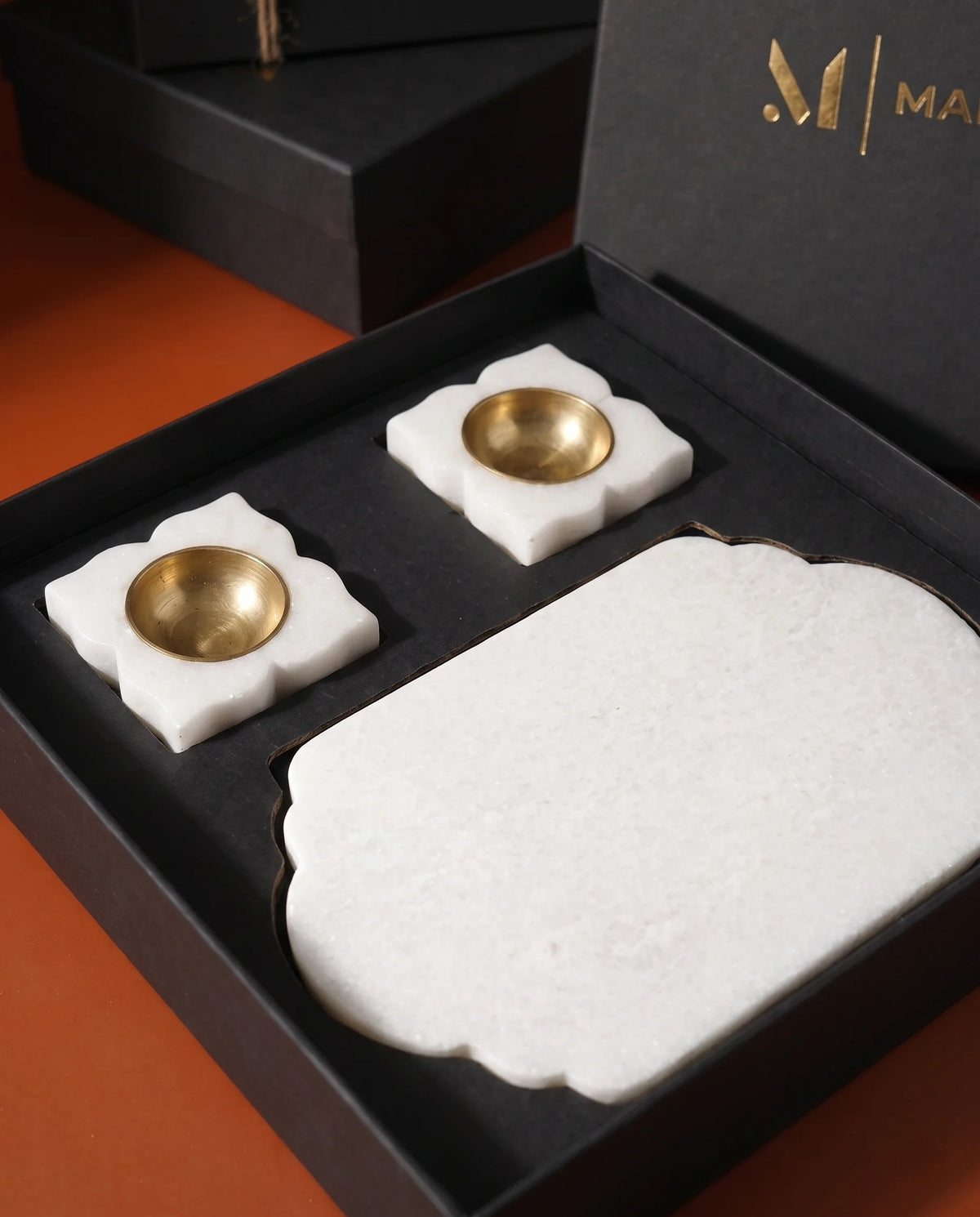 Angled view of a white scalloped-end tray and matching holders in an open presentation box.