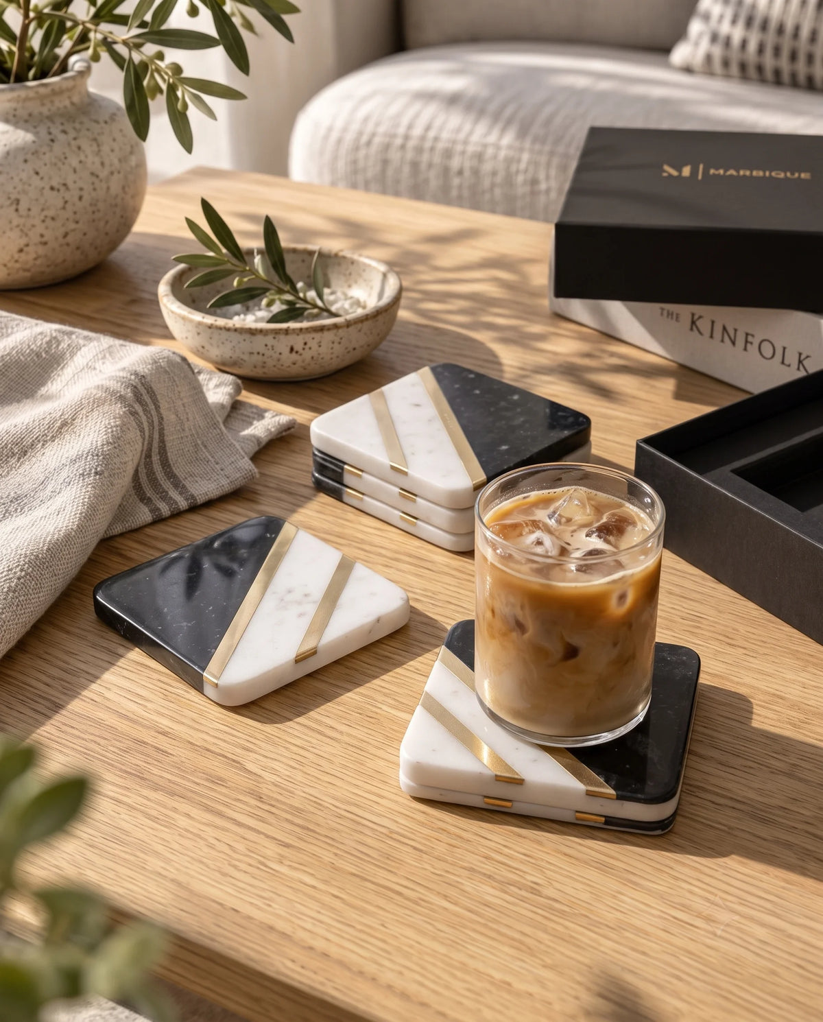 Black and white square coaster design with pale speckling and diagonal gold-tone strips.