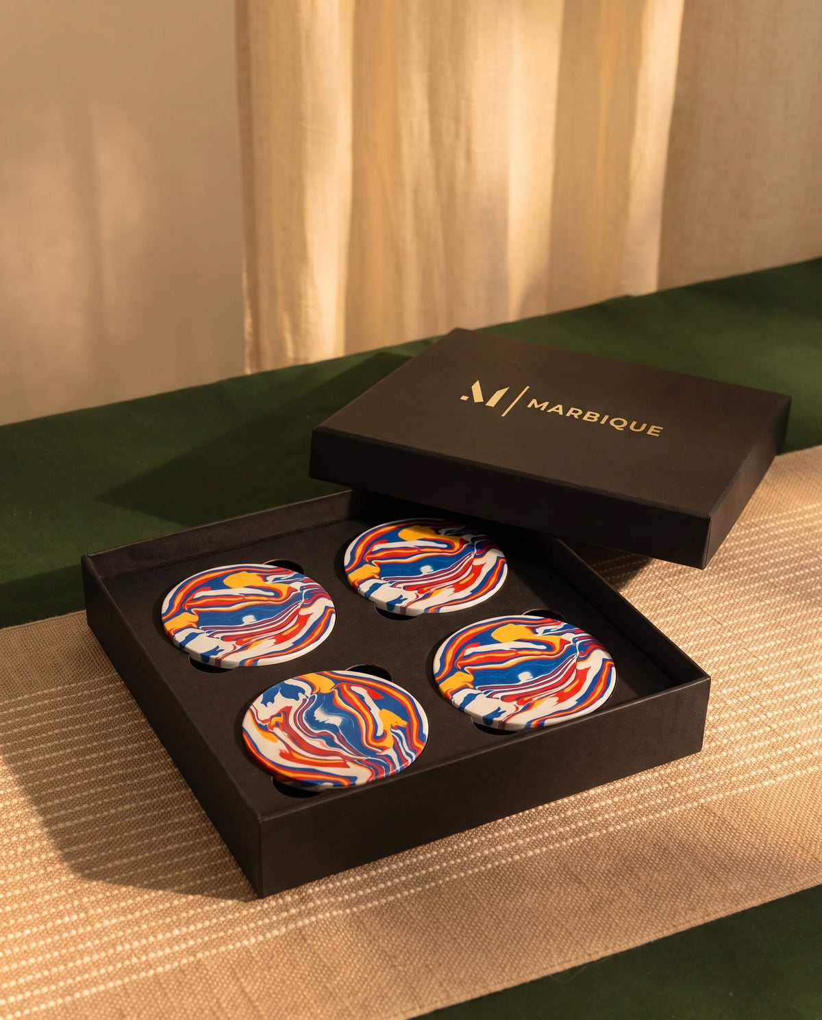 Round coaster design with flowing blue, red, yellow and white bands.