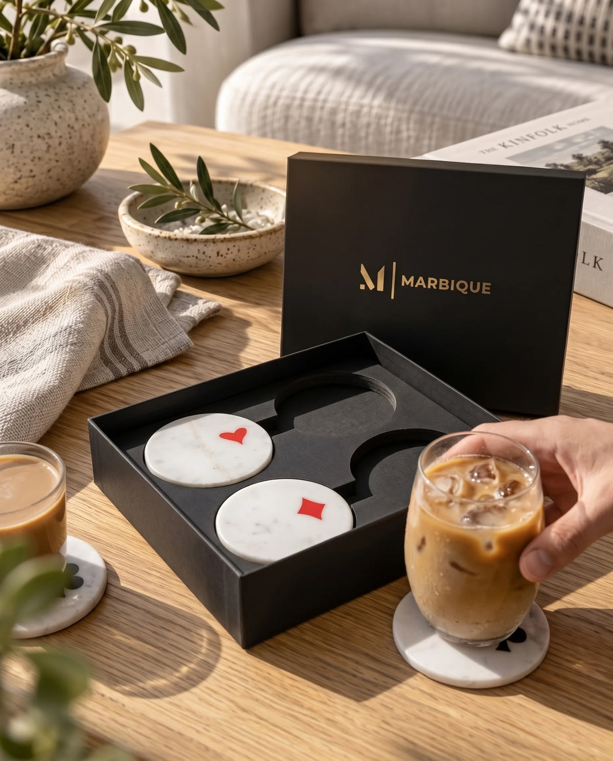 White square coaster designs with rounded corners, diagonal blue sections and gold-tone line details.