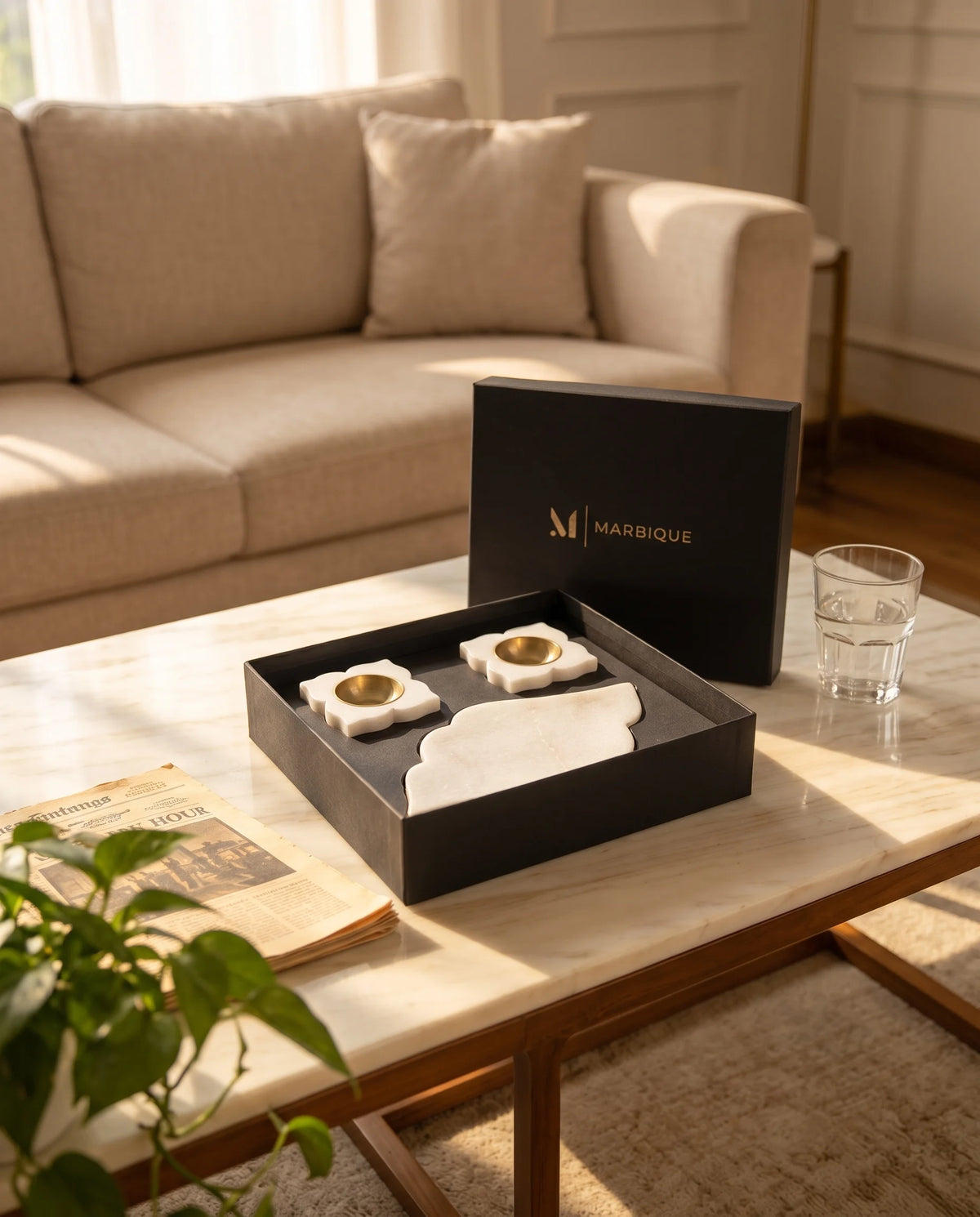Angled view of a white shaped tray with pointed ends and matching four-petal holders inside a black box.