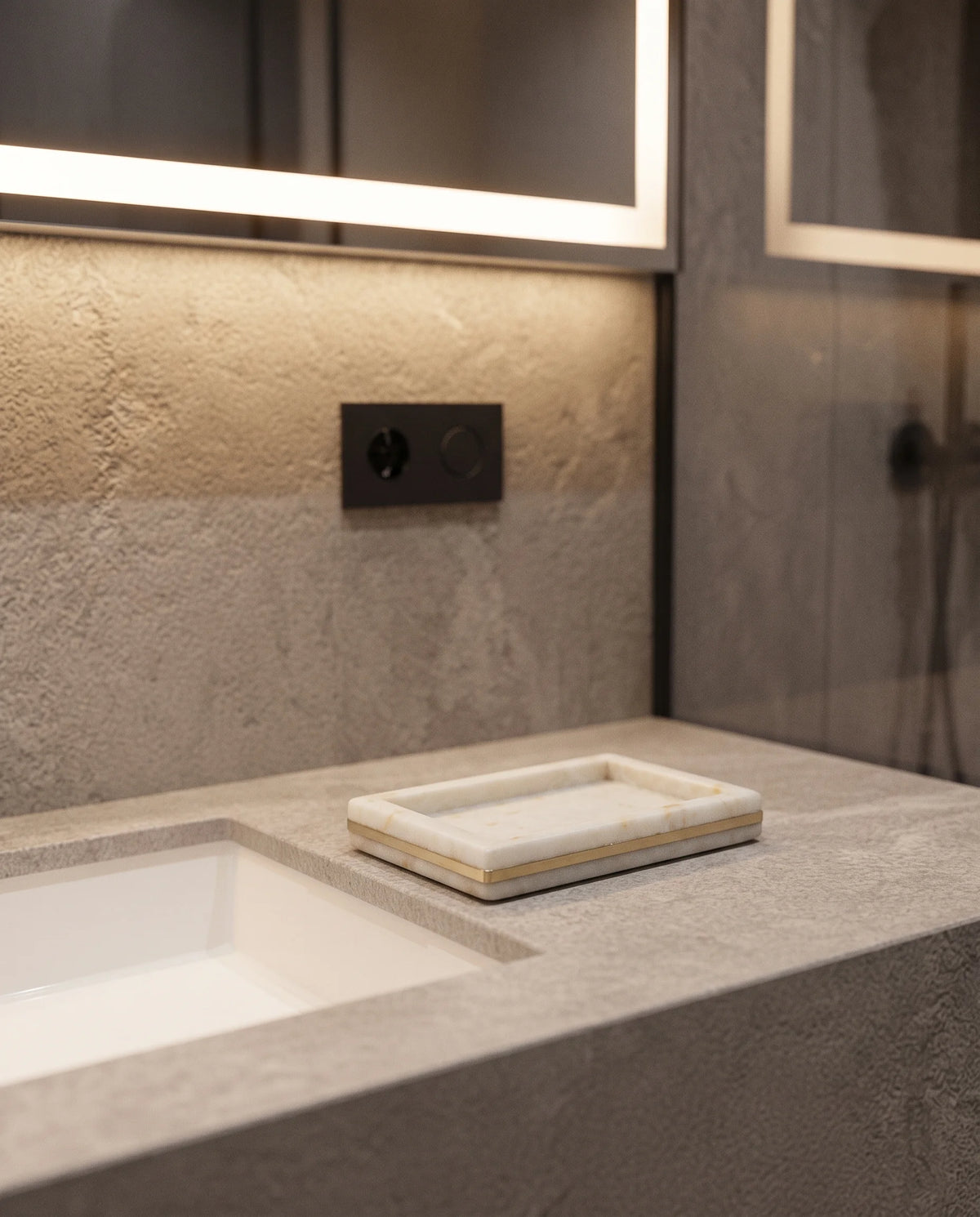 Small white rectangular raised-edge dish with a gold-tone band on a bathroom counter.