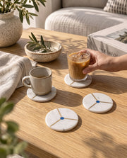 White circular coaster design with grey veining, a black diagonal stripe and gold-tone borders.