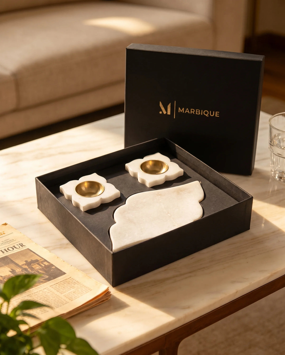 Close-up of the gold-tone cups and shaped white holder bases beside the scalloped tray.