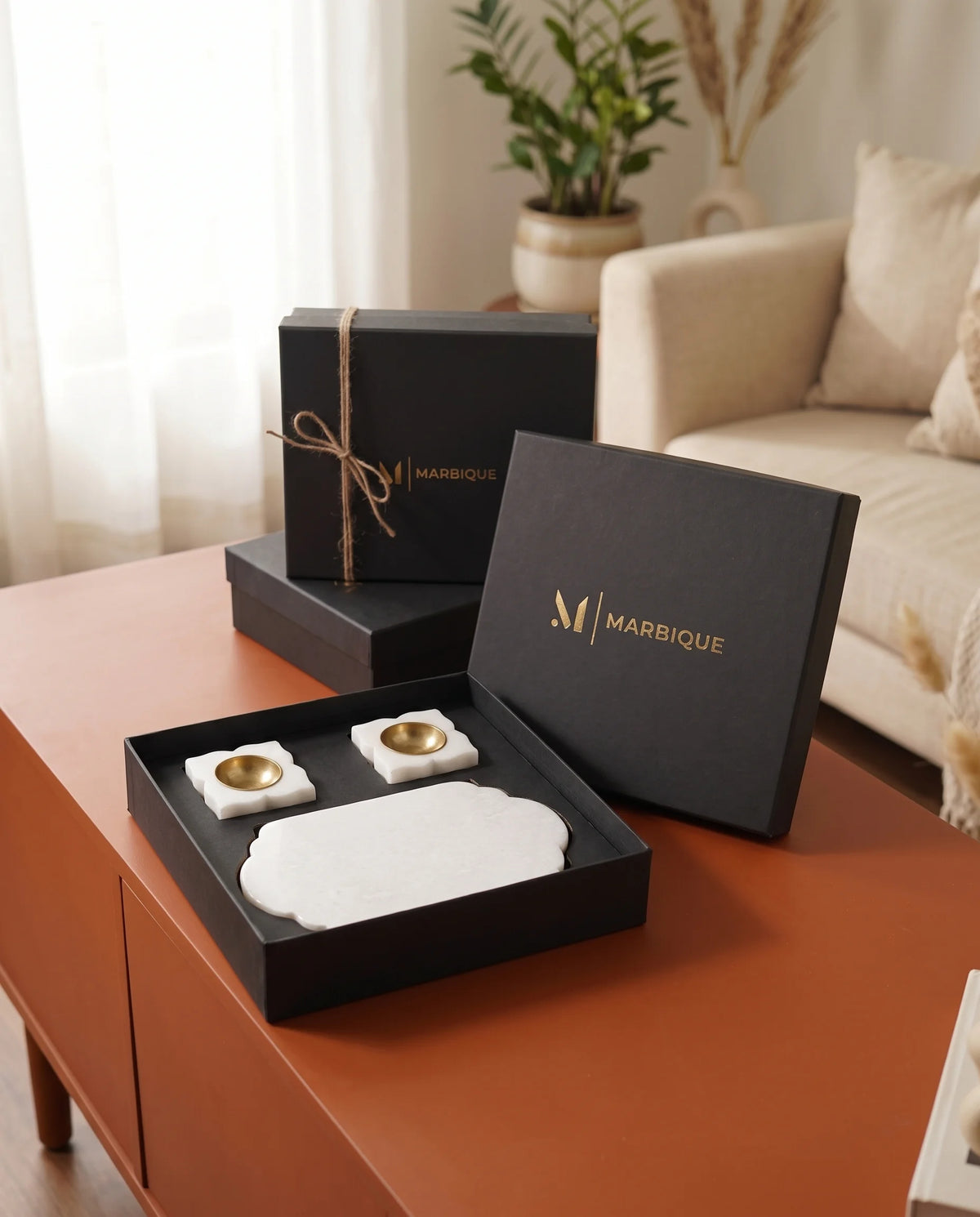 Overhead view of the oblong white tray and two white holders with round gold-tone cups.