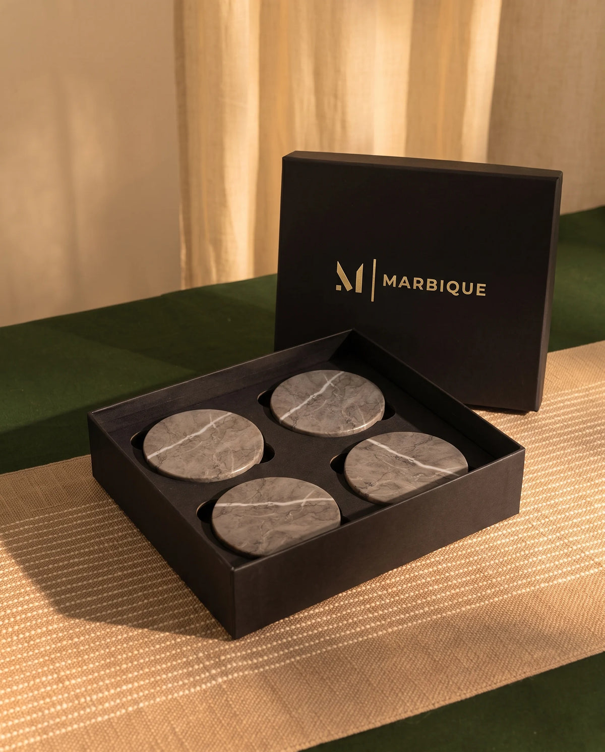 Round grey coaster with pale veining styled as a table accessory.