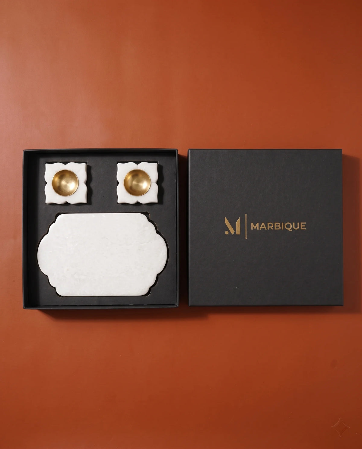Close view of the scalloped tray end and gold-tone-cup holder designs in black packaging.