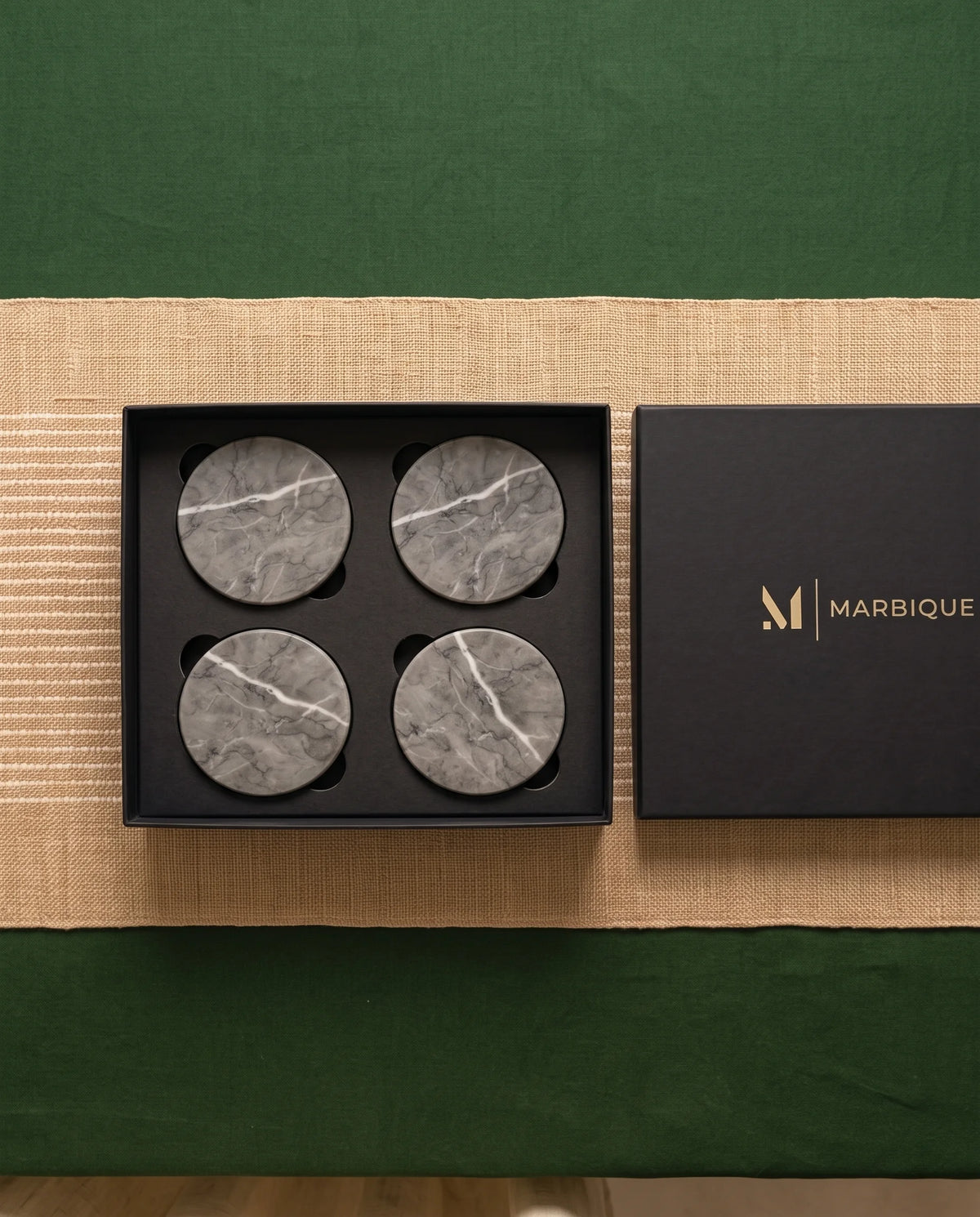 Grey round coaster designs with contrasting white veins arranged in a table setting.
