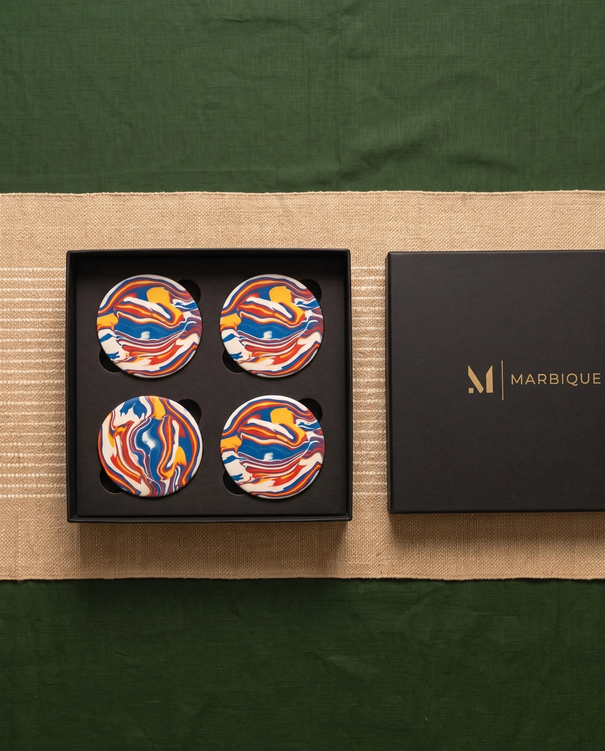 Round coasters with bright flowing swirl patterns in blue, red, yellow and white.