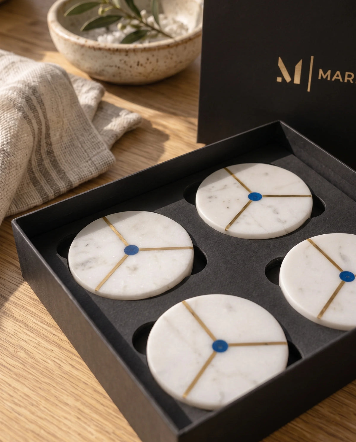 White round coaster with a contrasting black band and gold-tone line details, styled for a drinks setting.