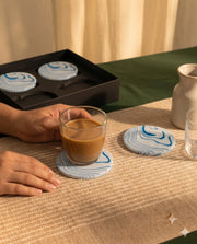 Black circular coaster designs with rows of contrasting white moon-phase shapes.