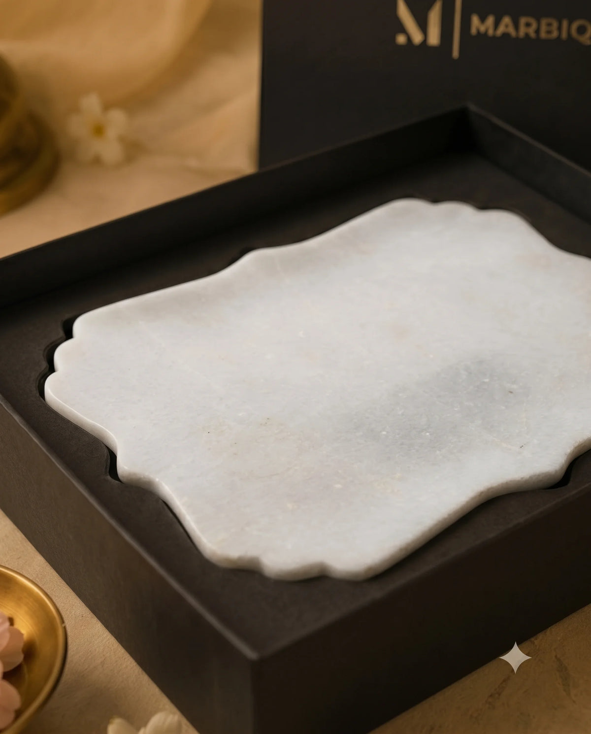White ornamental rectangular tray with scalloped edges inside a black Marbique presentation box.