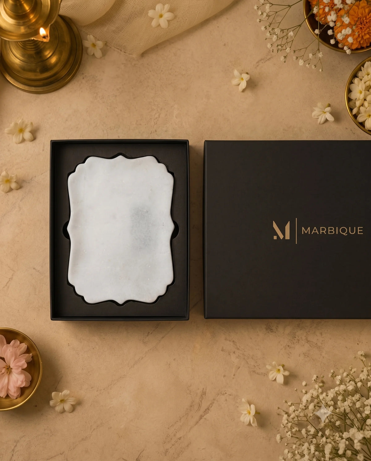 Overhead view of the white ornamental rectangular tray and black Marbique box lid.