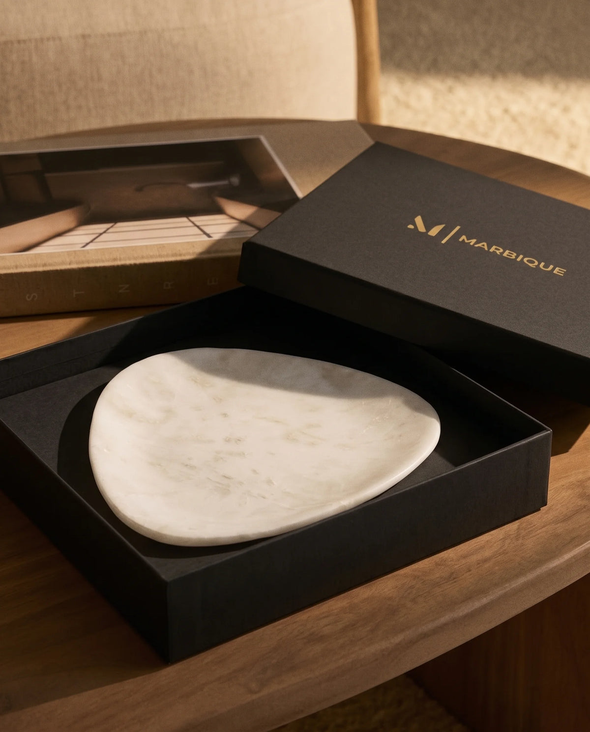 White rounded triangle tray displayed with black Marbique presentation packaging.