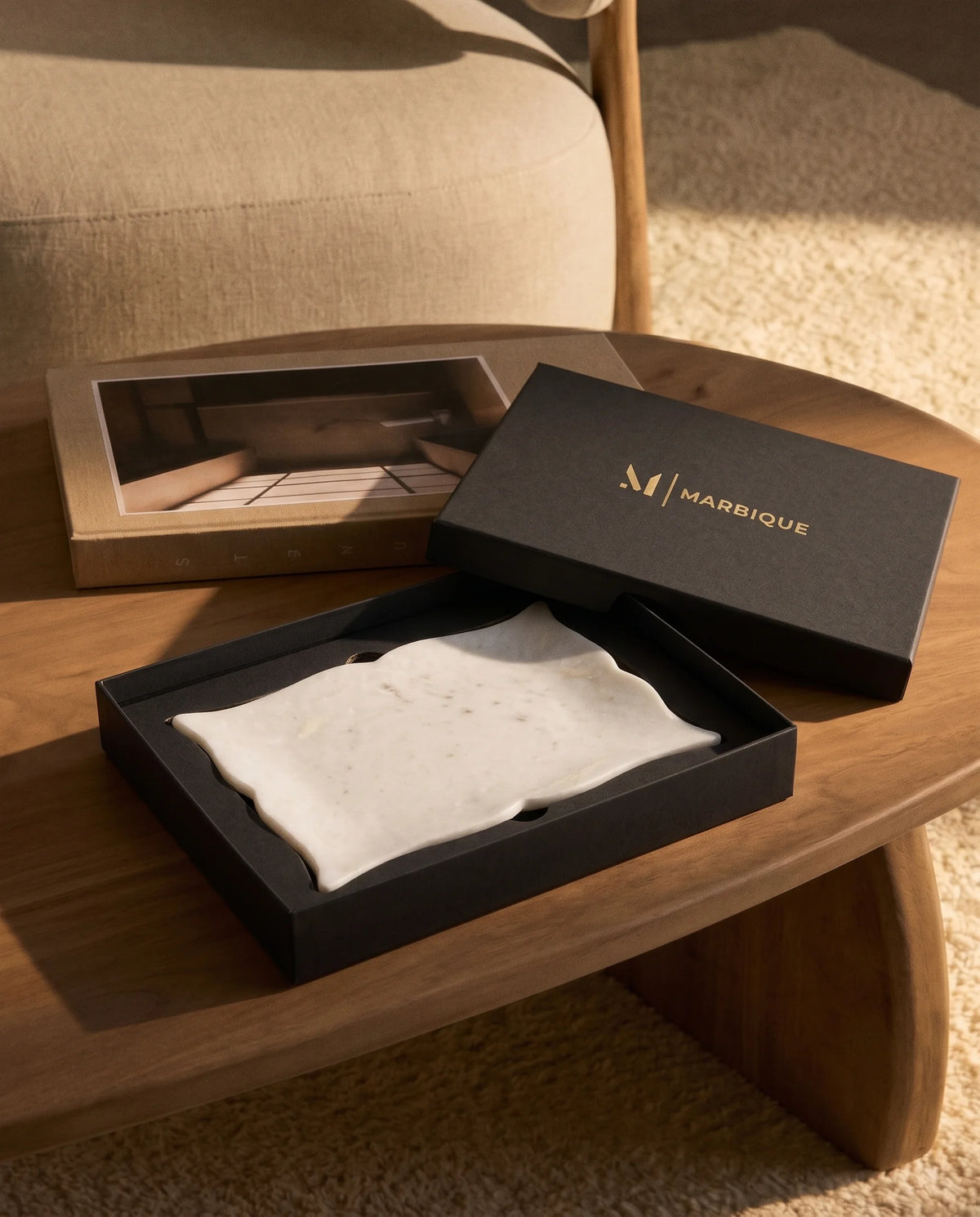 White pointed scalloped tray displayed with black Marbique presentation packaging.