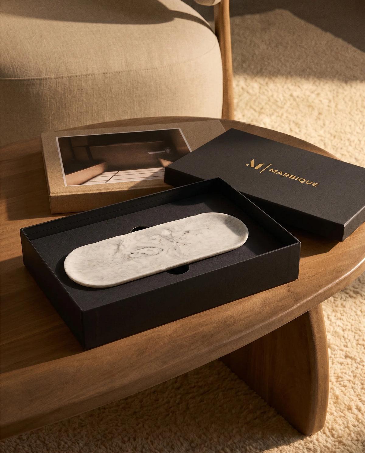 White elongated oval tray with a raised edge and grey veining in a black Marbique box.