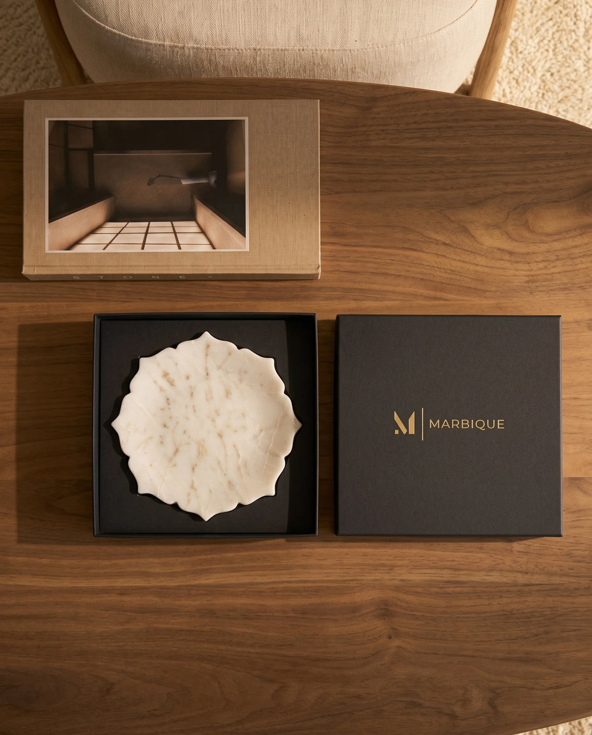 White scalloped round tray with pointed accents and subtle veining in a black presentation box.