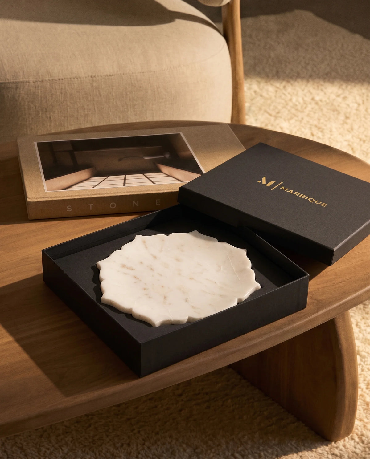 White round ornamental tray displayed with black Marbique packaging.
