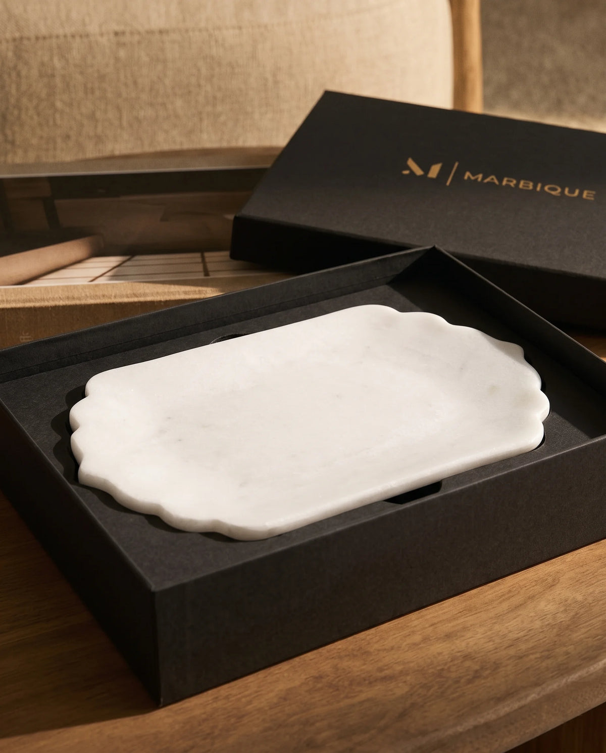 White oblong tray with scalloped ends in an open black Marbique box.