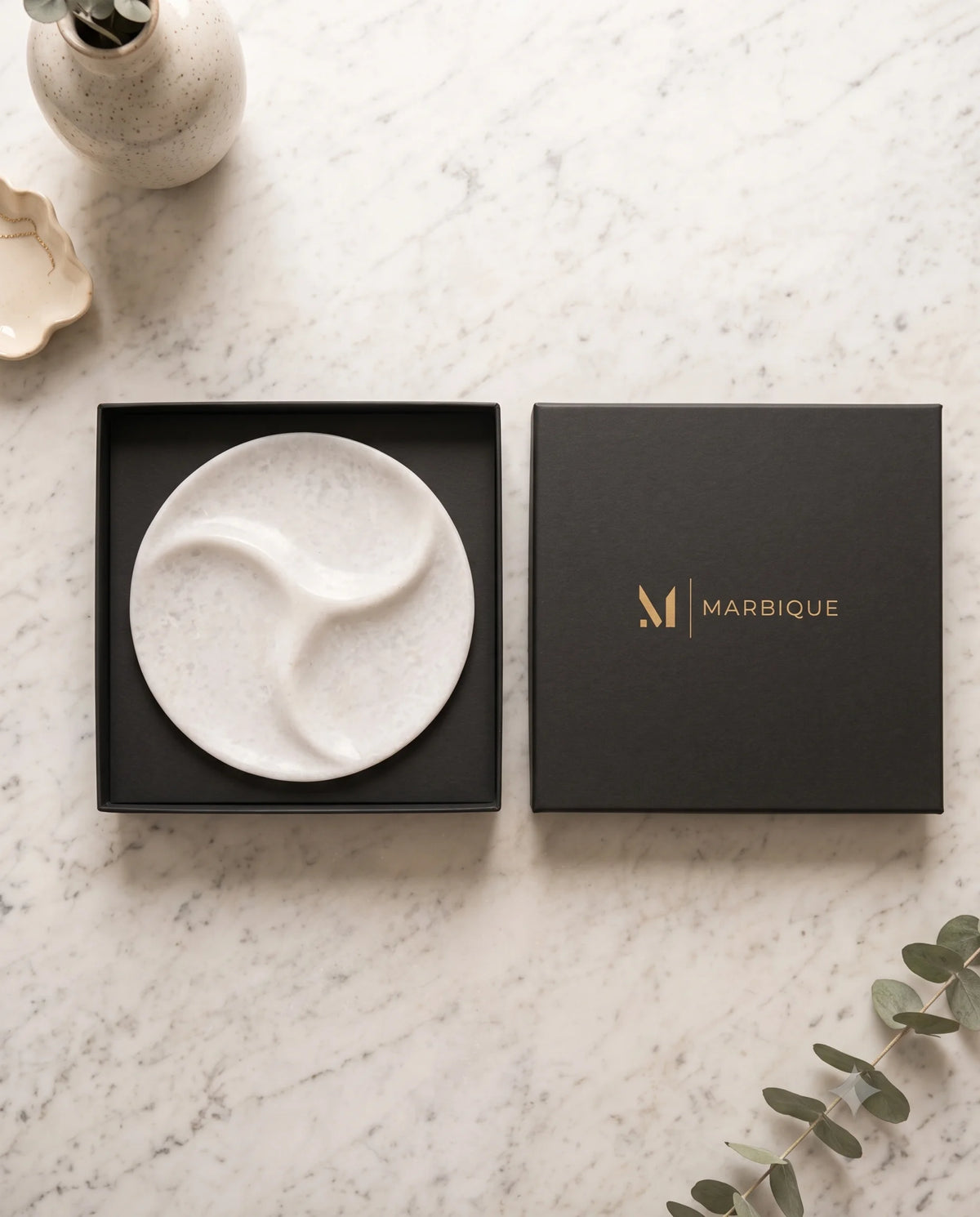 Close view of the sculpted curved recesses in a white round tray.