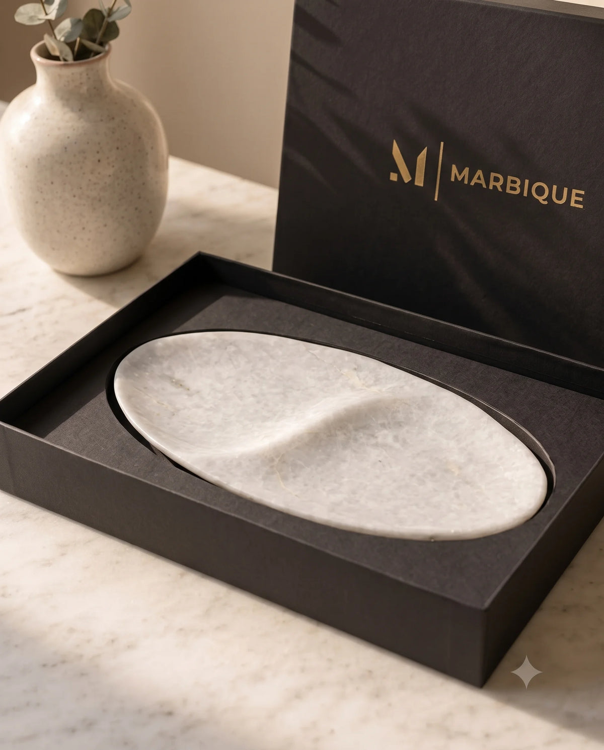 White oval two-section tray with a raised divider in an open black Marbique box.