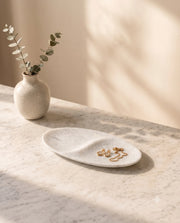 White oval tray showing two recessed sections and its central raised divider.
