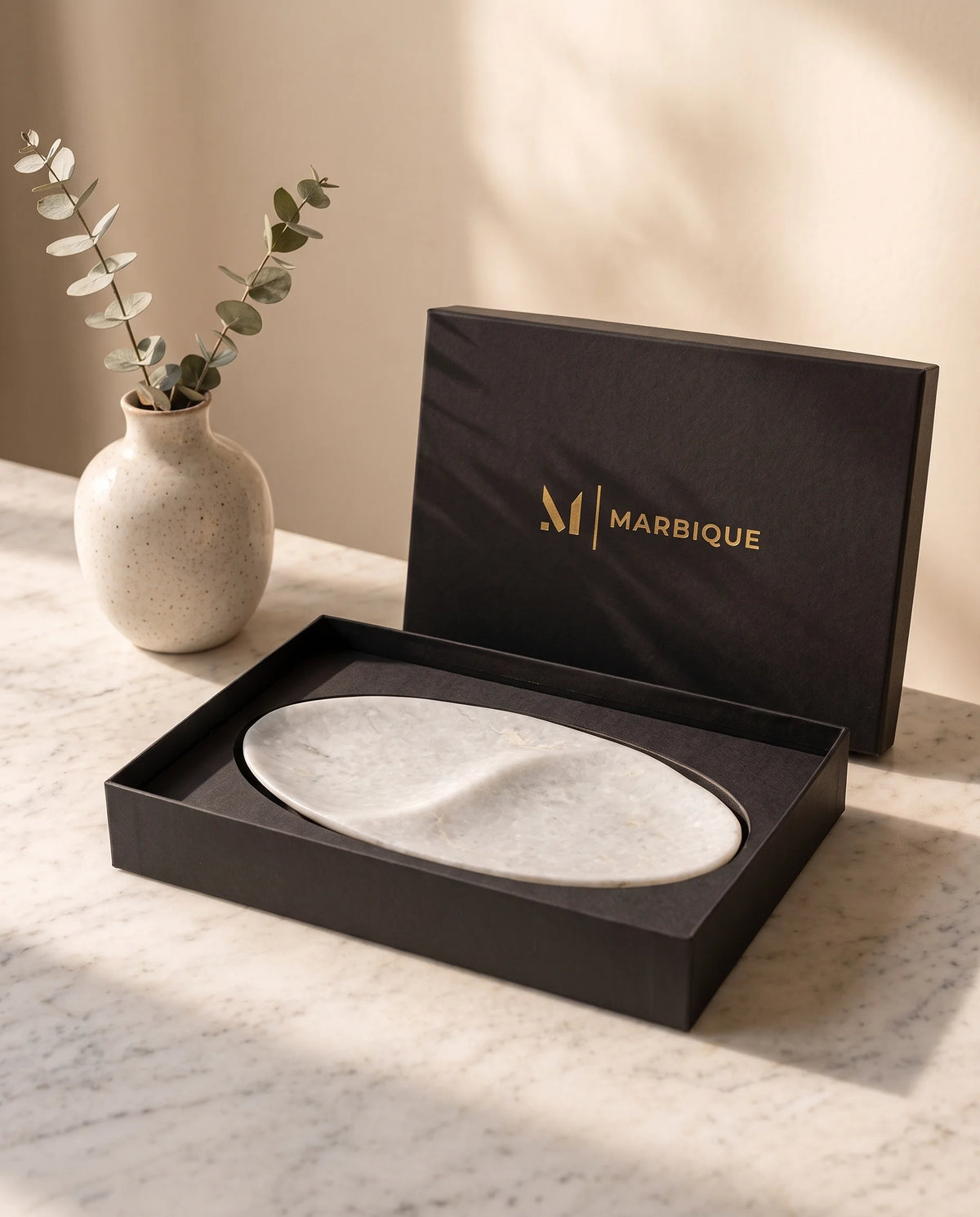 White two-section oval tray displayed with black Marbique presentation packaging.