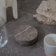 Elegant grey marble coasters set of 4 - authentic Italian stone with natural patterns stacked with white cup