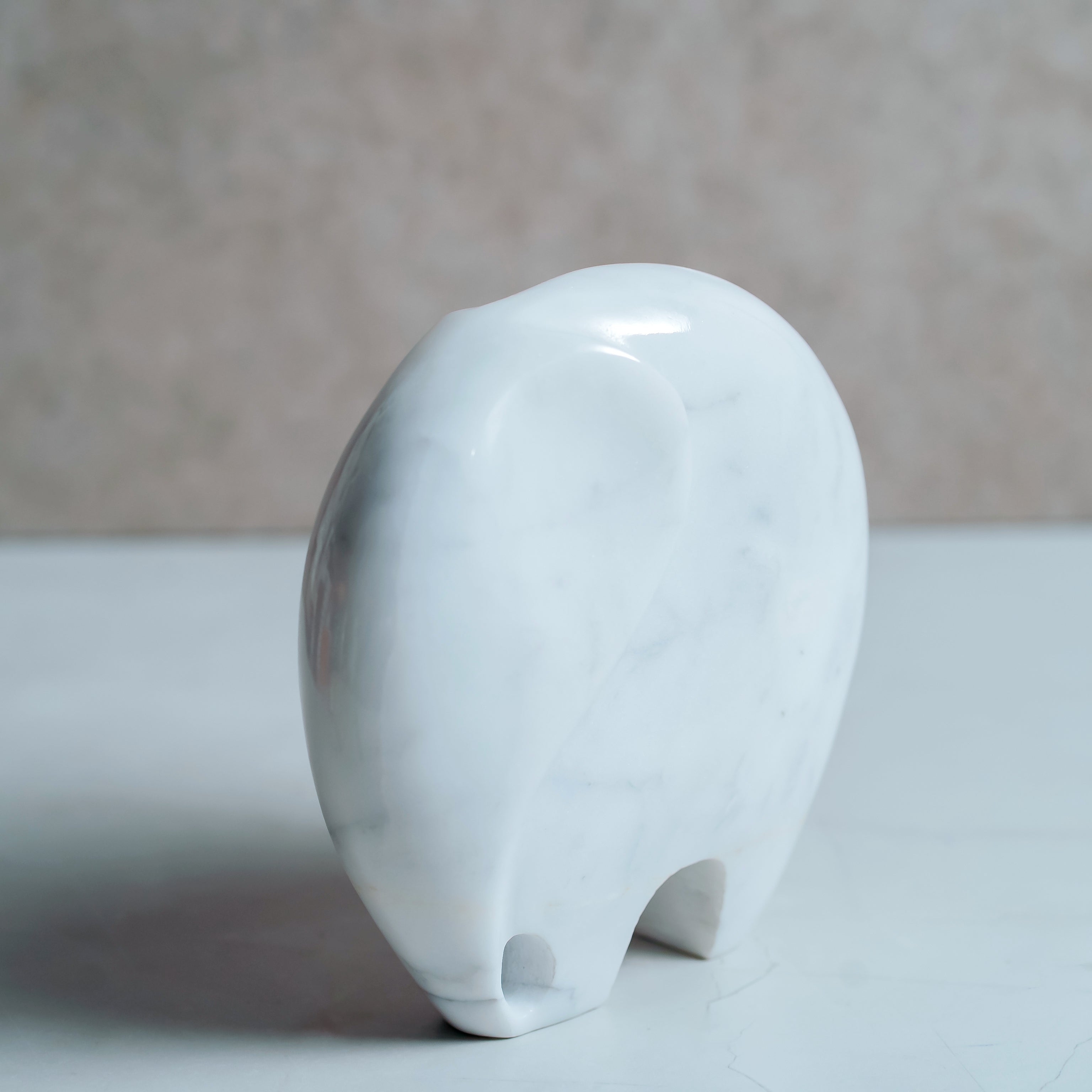 White marble elephant sculpture back view showing smooth polished surface and curved design
