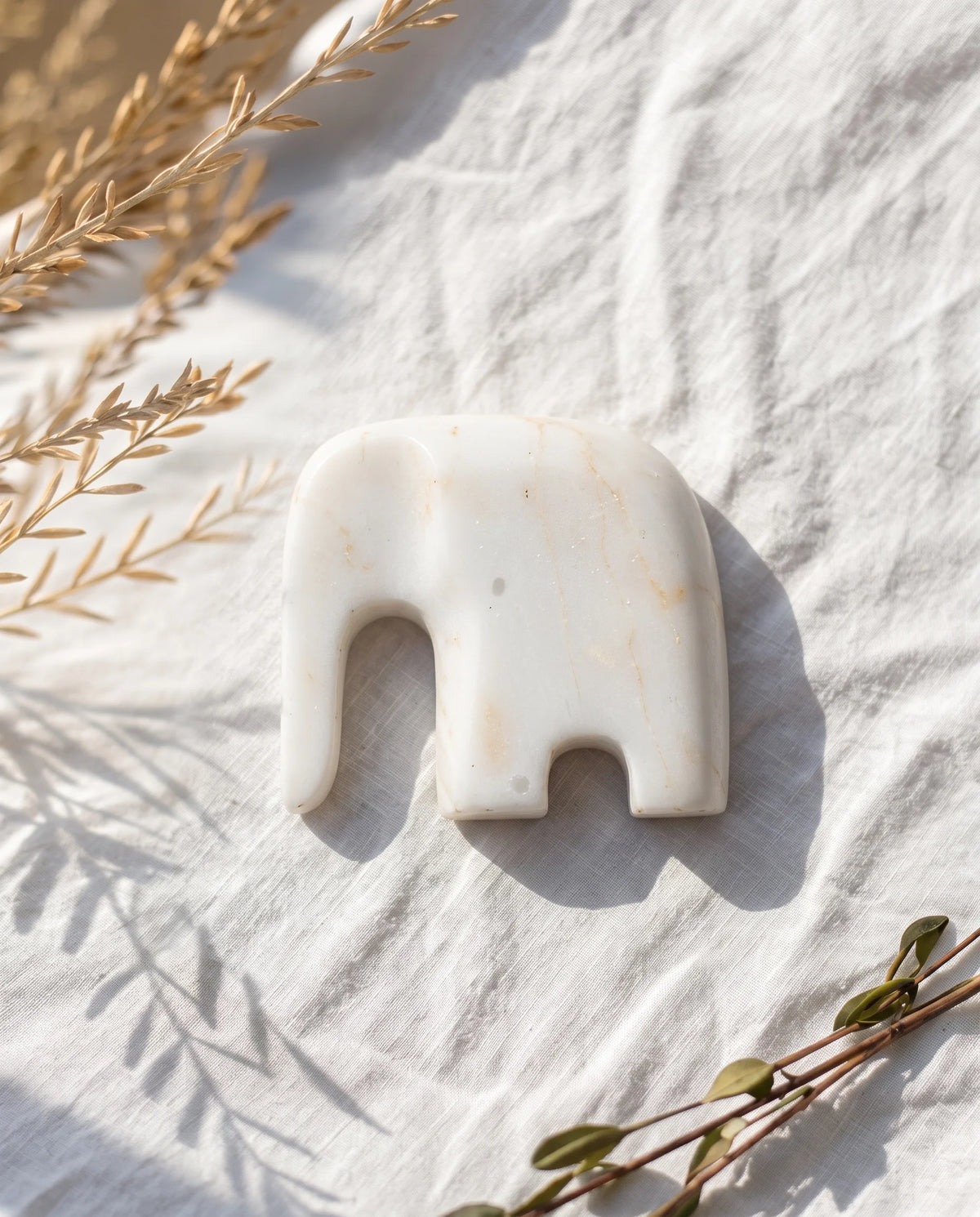 Overhead view of the white elephant form showing the long trunk and openings beneath its body.