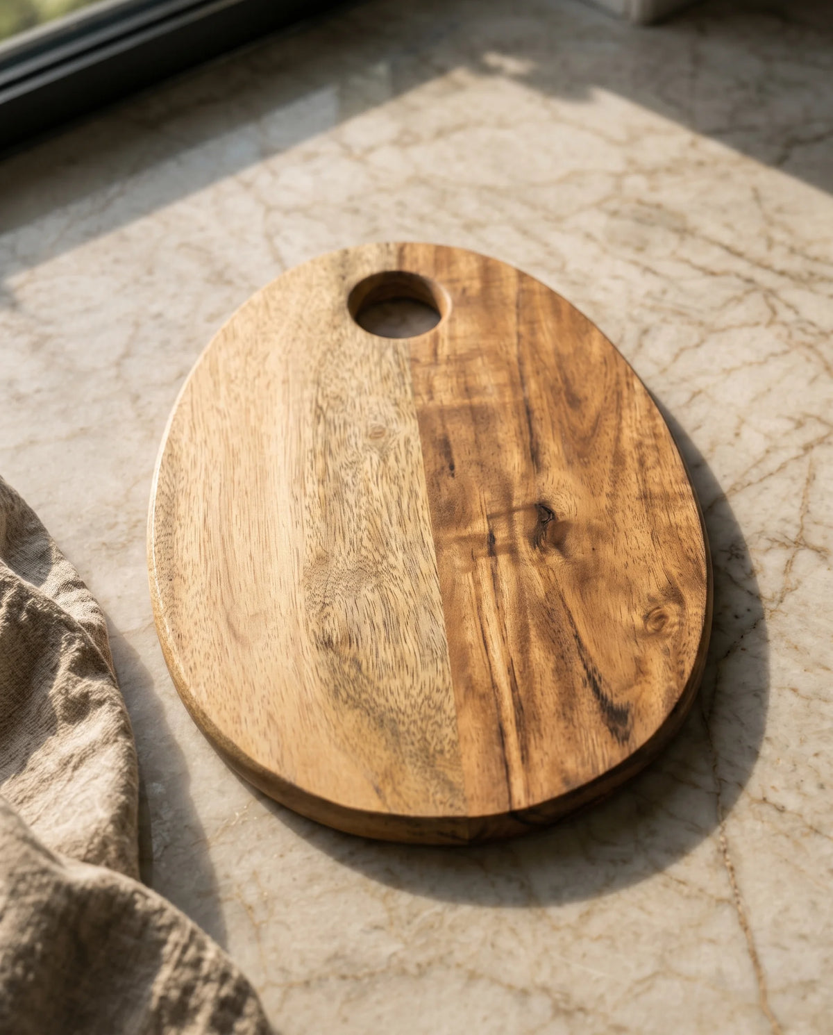 Close view of the oval board showing light and dark brown sections and a round opening.