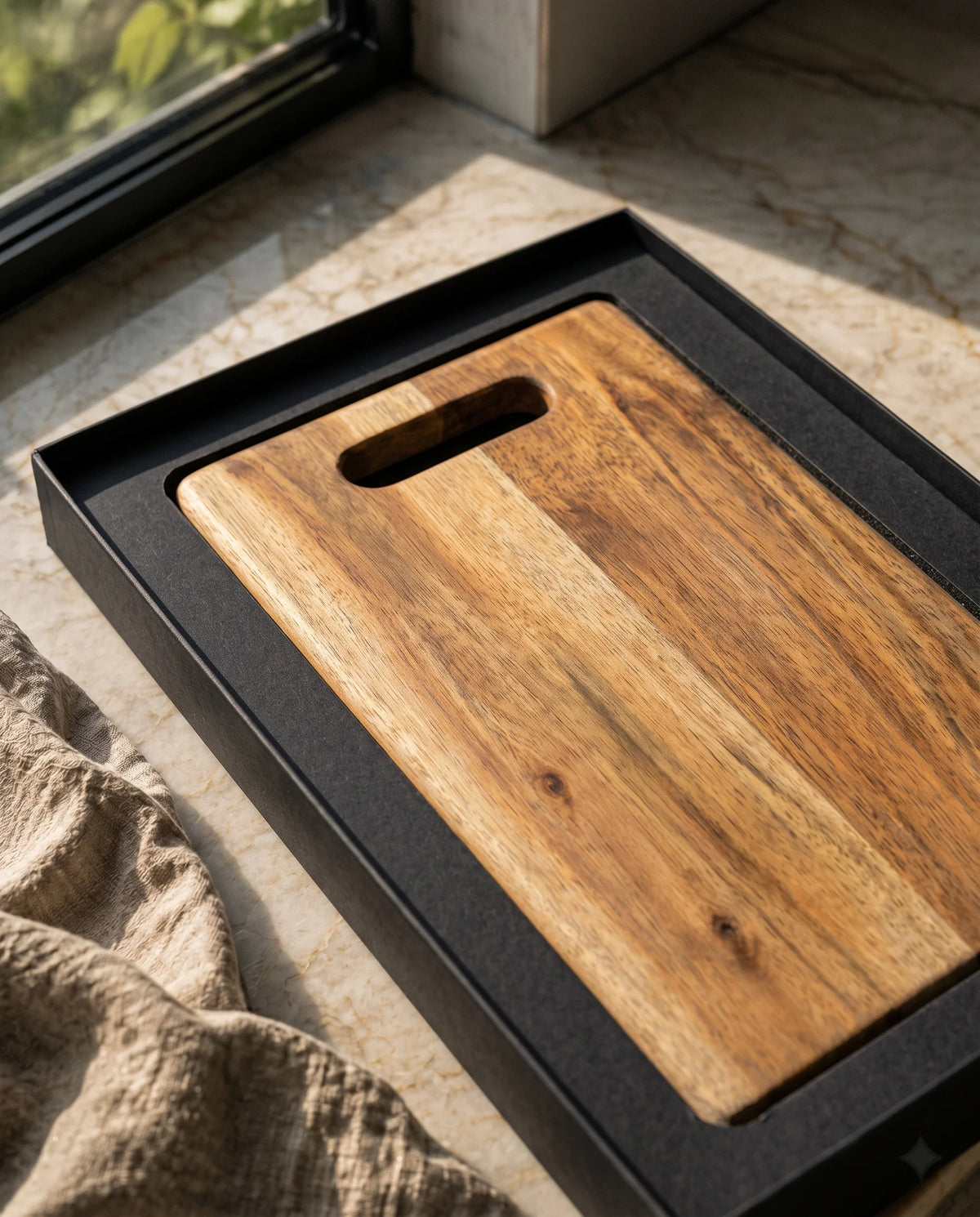 Close-up of the elongated grip slot and brown surface of a board inside black packaging.